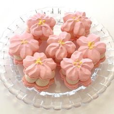 small pink and yellow flowers on top of some cookies in a glass plate with water