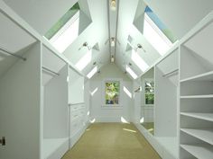 an empty room with white walls and open shelving units in the ceiling, along with carpeted flooring