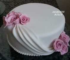 there is a white cake with pink flowers on it