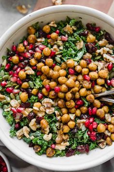 a white bowl filled with chickpeas, pomegranates and nuts