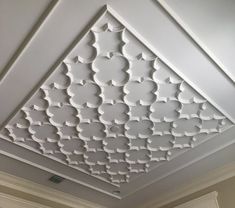 the ceiling in this room is decorated with white paint and decorative designs, including an intricate pattern