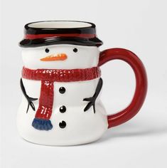 a ceramic snowman mug with a red handle