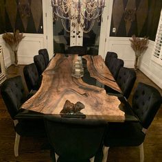 a dining room table with black chairs and a chandelier