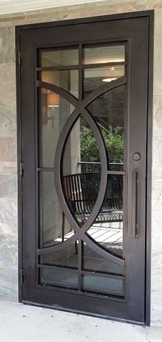 the front door to a home with glass and wrought iron designs on it's sides