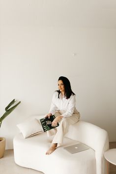 a woman sitting on top of a white couch