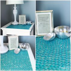 the table is covered in blue glass and has pictures on it, including two silver bowls