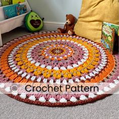 there is a crochet rug on the floor with a teddy bear next to it