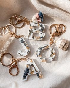 four key chains with letters and seashells on them