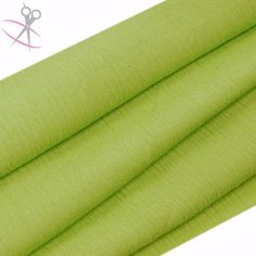 a green fabric with scissors on the top and one piece of cloth next to it