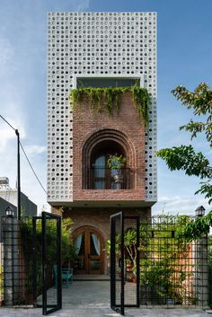 an entrance to a brick building with black gates and green plants on the outside wall