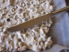 a knife is laying on top of a pizza covered in cheese and meat mixtures