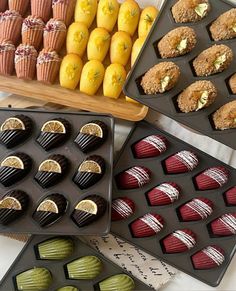 there are many different types of desserts in the trays on the table together