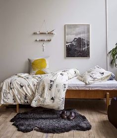 a bed sitting in a bedroom next to a wooden table and chair on top of a hard wood floor