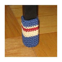 a small crocheted cell phone case sitting on top of a wooden floor