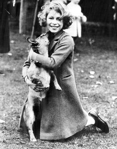 an old photo of a woman holding a dog in her arms and smiling at the camera