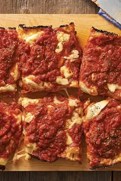 square slices of deep dish pizza on a cutting board