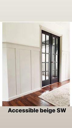 an empty room with white walls and wooden floors, black doors and glass panels on the wall