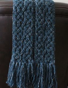 a blue knitted scarf sitting on top of a couch