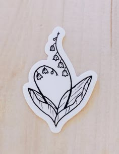 a sticker with a flower on it sitting on top of a piece of wood