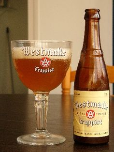 a bottle and glass sitting on a table next to each other with a beer in it