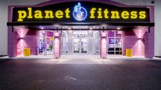 the entrance to planet fitness is lit up in pink and purple colors with neon lights