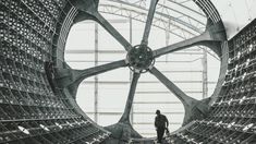 a man standing in the middle of a large metal structure