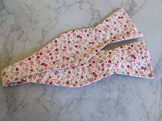 Upgrade your wardrobe in style with this stunning white and pink coloured floral bow tie. Perfect gift for him, this unique fully adjustable bow tie will elevate any occasion including weddings, birthdays and anniversaries. Made from cotton. Pink Floral Bow Tie, Adjustable White Bow Tie With Butterfly Knot, Adjustable White Bow Tie With Decorative Bow, White Spring Party Bow Tie, Pink Bow Tie As Gift, Pink Bow Tie Gift, Pink Bow Tie Perfect As Gift, Pink Bow Tie For Gift, White Adjustable Bow With Butterfly Knot