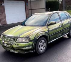 a green car parked in front of a house