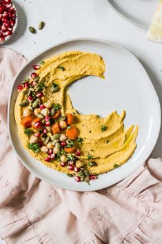 a white plate topped with hummus and vegetables