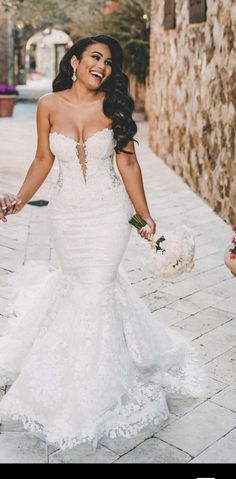 a woman in a wedding dress walking down the street