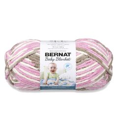 bernat baby blanket yarn in pink, beige and white with an image of a baby on