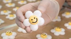 a person holding a flower with smiley faces on it