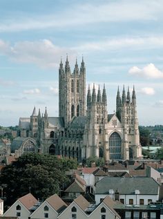 an old cathedral towering over a city with tall buildings in the foreground and blue sky