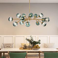 a dining room table with green chairs and a chandelier hanging from the ceiling