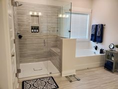 a bathroom with a shower, toilet and bathtub next to a rug on the floor