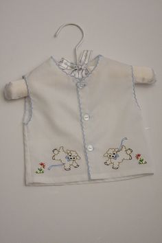 Newborn boy or girl diaper shirt with little lambs embroidery and a scalloped edging.  Made with White Imperial Broadcloth with is a Poly/Cotton blend for easy care.  Adorable on any newborn baby! The boy's shirt is trimmed in blue and the girls shirt is trimmed in pink.   These items are made to order.  Check shipping for ship by date.  If you need earlier you may message me and I will let you know if I can accommodate. NOTE:  I have a few of these ready to ship.   Please contact me to  see wha Newborn Baby Dress Embroidery, Newborn Embroidery, Diaper Shirt, Linen Gown, Kids Embroidery, Miniature Embroidery, Kids Vest