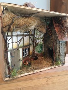 a miniature house made out of cardboard on a table