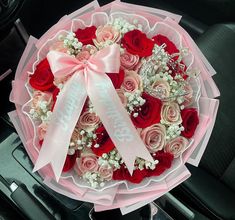 a bouquet of roses in the center of a car with a ribbon that says happy valentine's day