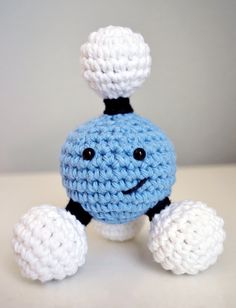 a crocheted blue and white toy with a black top on it's head