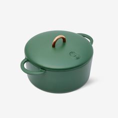 a green casserole with wooden handle on a white background and the lid is open