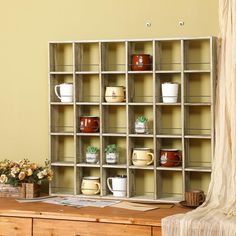 a wooden table topped with lots of cups and vases on top of it's shelves