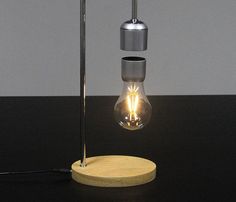 a light that is on top of a black table with a wooden plate underneath it