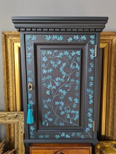 an ornate cabinet with blue flowers painted on the front and sides, along with other antique items