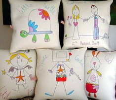 four decorative pillows with children's drawings on them