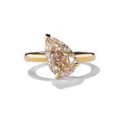 a yellow gold ring with a pear shaped diamond