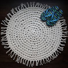 a white and blue placemat on a wooden table with a blue bow laying on it