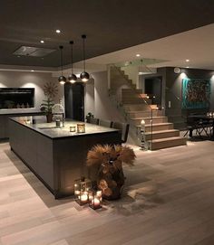 a large kitchen with candles on the counter and stairs leading up to an open floor plan