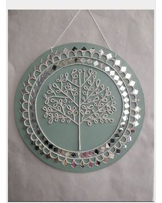 a circular metal wall hanging with a tree on it