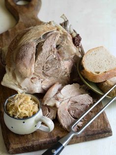 a wooden cutting board topped with meat and bread