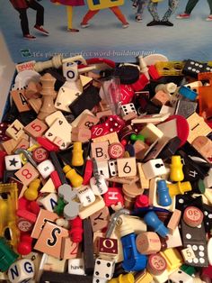 a pile of wooden toys with numbers and people on the cover in front of them